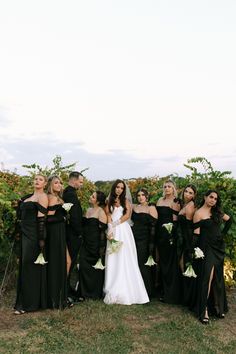 a group of women standing next to each other on top of a lush green field