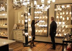 a man and woman looking at lights in a store