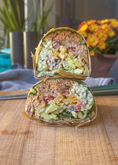 two sandwiches sitting on top of a wooden table