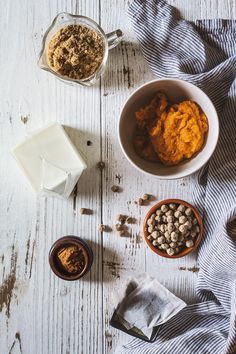 two bowls filled with food sitting on top of a white wooden table next to milk