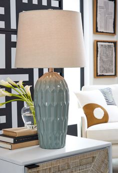 a blue vase sitting on top of a table next to a lamp