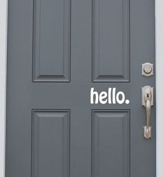 a gray door with the word hello written on it and a metal handle that says hello