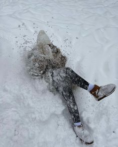 a person laying in the snow on their back