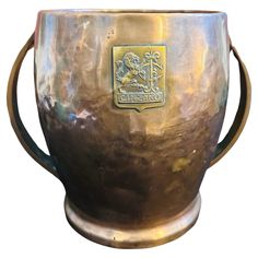 a large metal cup with a gold emblem on it