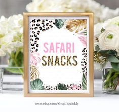 a sign that says safari snacks in front of some flowers and vases with white roses