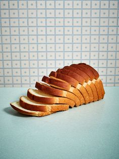 a sliced loaf of bread sitting on top of a blue counter next to a wall