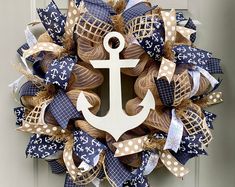 a wreath with an anchor and burlocks is hanging on the front door,