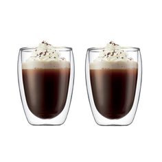 two glasses filled with liquid and topped with whipped cream on the top, sitting next to each other