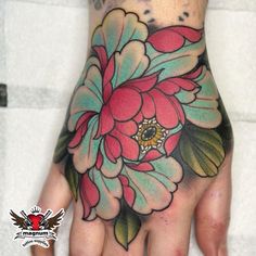 a woman's hand with a flower tattoo on it