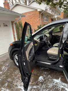 a car with its door open sitting in front of a house