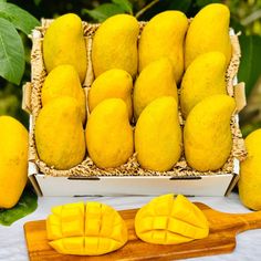 a bunch of mangos sitting on top of a cutting board next to some cut up pieces