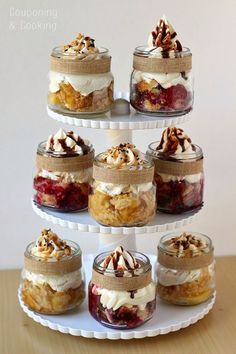 there are many desserts in glass jars on the cake stand