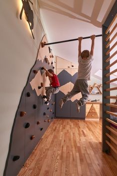 two boys are climbing up the side of a wall