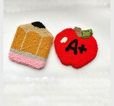 two knitted apples and an apple shaped object