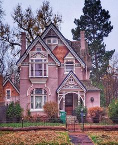 a large pink house sitting on the side of a road