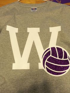 a t - shirt with the word w on it and a volleyball in the middle