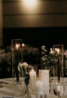 the table is set with candles, flowers and wine glasses for an elegant wedding reception