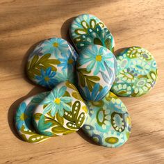 four painted rocks sitting on top of a wooden table