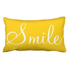 a yellow and white pillow with the word smile written in cursive font on it