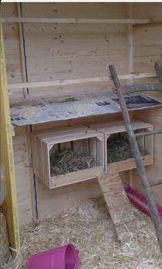 the inside of a chicken coop with hay and ladders