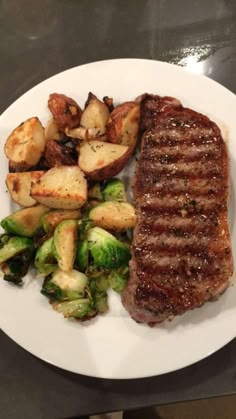 steak, potatoes and brussel sprouts on a white plate