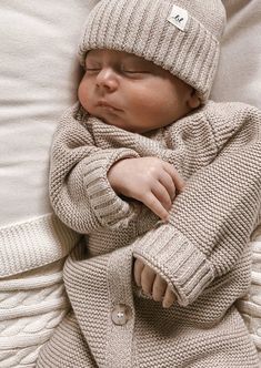 a newborn baby wrapped in a sweater and hat