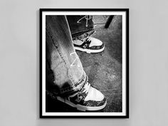 a black and white photo of someone's feet wearing sneakers