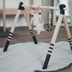 a child's play gym with wooden beads and stars on the bars, black and white