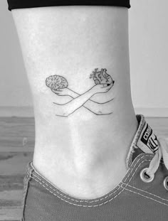 a woman's foot with a small tattoo on the side of her leg, which is