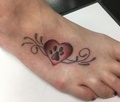 a foot with a dog's paw and heart tattoo on it