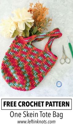 a crochet bag with flowers and scissors on the side, next to it