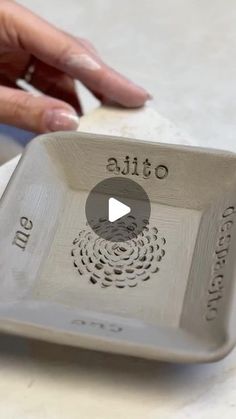 a person is cutting into a square shaped object with the word otta on it