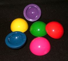 six plastic balls with different colors on a black surface