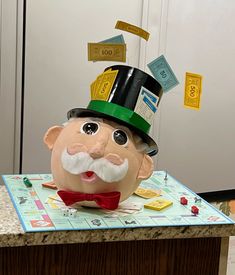 an odd looking plastic head sitting on top of a counter next to a board game