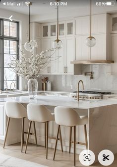 an image of a kitchen setting with white cabinets and marble countertops in the center