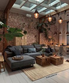 a living room filled with lots of furniture and plants on the wall above it's windows