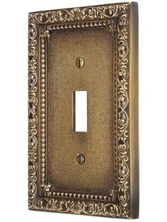 an antique light switch cover with ornate designs on the front and back plates in bronze