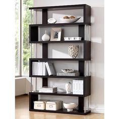 a book shelf with books and a vase on top