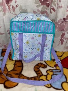 a winnie the pooh diaper bag sitting on top of a bed