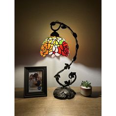 a stained glass lamp sitting on top of a wooden table