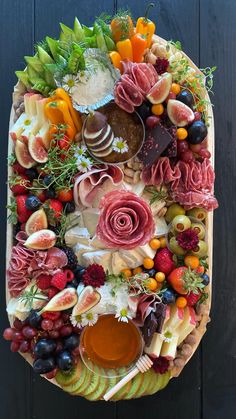 a platter filled with meats, fruit and veggies