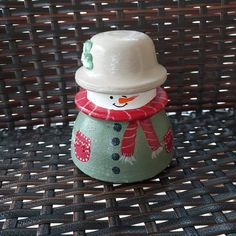 a small ceramic snowman sitting on top of a table