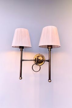 two lamps mounted on the wall next to each other, one light is turned off