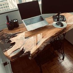 a desk with two laptops and a mouse on it in front of a window