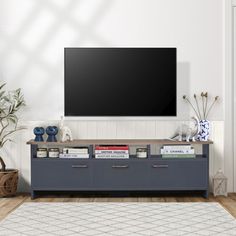 a flat screen tv mounted to the side of a wall in a living room with white walls