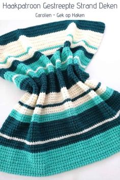 a crocheted blue and white striped scarf on a white surface with the top folded up