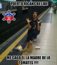 a man sitting on the ground in front of a train station with his hands up