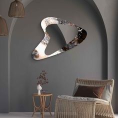 a room with a chair, table and mirror on the wall next to an arch