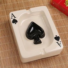 a playing card shaped ashtray sitting on top of a table