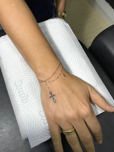 a woman's hand with a cross tattoo on it